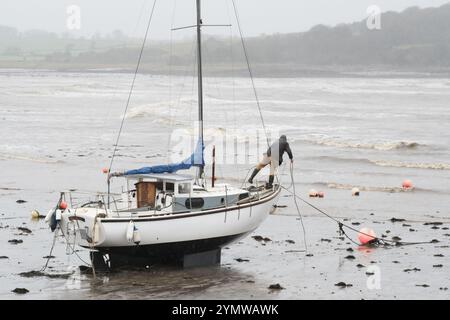 Garlieston, Wigtownshire, Schottland – Wetter in Großbritannien – Samstag, 23. November 2024 – Ein Matrose überprüft seine Anlegeplätze seiner Yachten, während die starken Winde vom Sturm Bert die aufsteigende Flut in den Hafen von Garlieston im Südwesten Schottlands treiben – Foto Steven May / Alamy Live News Stockfoto