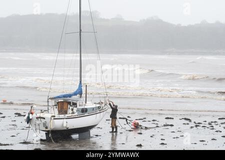 Garlieston, Wigtownshire, Schottland – Wetter in Großbritannien – Samstag, 23. November 2024 – Ein Matrose überprüft seine Anlegeplätze seiner Yachten, während die starken Winde vom Sturm Bert die aufsteigende Flut in den Hafen von Garlieston im Südwesten Schottlands treiben – Foto Steven May / Alamy Live News Stockfoto