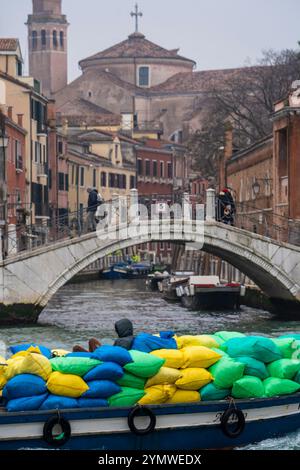 Boot voller Müll, der früh am Morgen von den Straßen Venedigs abgeholt wurde. Müllsammlung in einer Gondel. Venedig, Italien 04.01.2024 Stockfoto