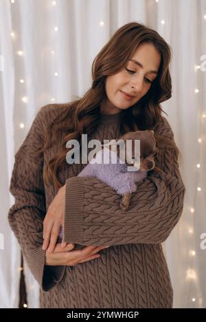 Frau, die Chihuahua in Cozy hält Stockfoto