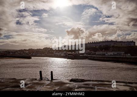 Die Sonne bricht über dem äußeren Hafen von Whitby vom East Pier aus. Stockfoto