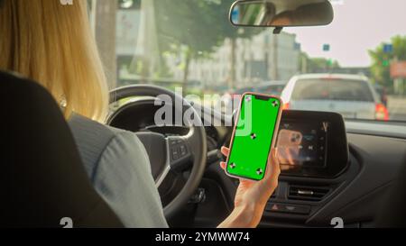 Unerkennbare kaukasische Geschäftsfrau Mädchen fahrende Autofahrerin weibliche Lenkradtransporte in der Stadt Autokäufer Frau, die Handy aussieht Stockfoto