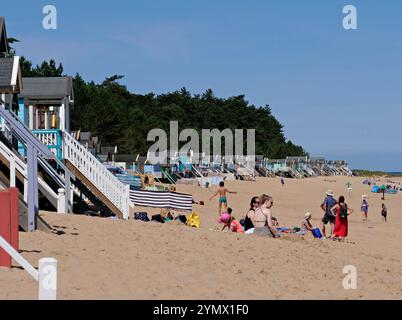 Touristen und Besucher am Strand von Wells mit Strandhütten im Vordergrund, Norfolk, England, Großbritannien Stockfoto