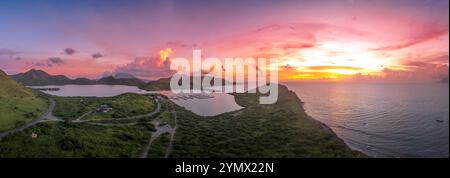 Dramatischer Sonnenuntergang über St. Kitts, Christophe Harbor farbenfrohe Sonnenstrahlen, die die Wolken rosa, rot und lila bemalen, während die Sonne über dem Nevis-Gipfel untergeht Stockfoto