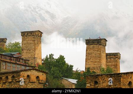 Mittelalterliche Svan Tower-Häuser mit atemberaubenden schneebedeckten Kaukasusbergen im Hintergrund, Stadt Mestia, Region Svaneti, Georgien, Europa Stockfoto