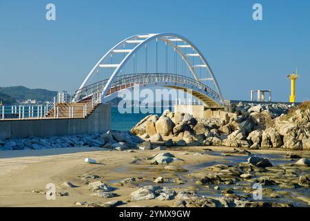 Yangyang County, Südkorea - 3. November 2024: Eine detaillierte Ansicht der weißen Bogenbrücke und des gelben Leuchtturms am Namae Sunrise Observatory, surr Stockfoto