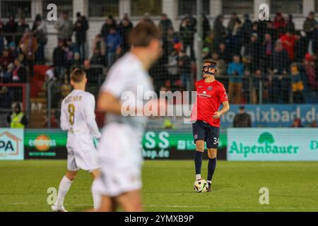 Unterhaching, Deutschland. November 2024. Tim Knipping (SpVgg Unterhaching, 34) mit Ball, mit Gesichtmaske. GER, SpVgg Unterhaching vs. SV Wehen Wiesbaden, Fussball, 3. Liga, 15. Spieltag, Saison 2024/2025, 23.11.2024, DFL-VORSCHRIFTEN VERBIETEN DIE VERWENDUNG VON FOTOGRAFIEN ALS BILDSEQUENZEN, Foto: Eibner-Pressefoto/Jenni Maul Credit: dpa/Alamy Live News Stockfoto