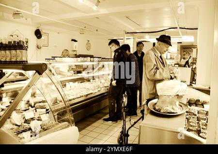 OXFORD, Großbritannien - 23. AUGUST 2017: Menschen kaufen Delikatessen im traditionellen Delikatessengeschäft des Historic Oxford Covered Market. Historisches Foto von Sepia. Stockfoto