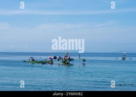 Laiya Beach, Batangas, Philippinen - 16. August 2024: Fischer, die mit dem frühen Morgencach an Land kommen. Die Menschen in den Dörfern der Küstenprovinz leben weiterhin auf traditionelle Weise Stockfoto