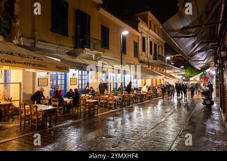 Athen, Griechenland - 26. November 2021: Sitzplätze im Freien in den traditionellen griechischen Restaurants in den zentralen Straßen von Athen, Griechenland. Stockfoto