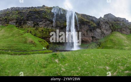 Seljalandsfoss Wasserfall in Island: Berühmte landschaftliche Schönheit umgeben von üppigem Grün, beliebtes Touristenziel für Fotografie und Naturforschung Stockfoto