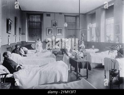 In einer männlichen Station des Royal United Hospital Bath, kümmern sich die Krankenschwestern um Patienten, umgeben von einer hellen Atmosphäre und dekorativen Einrichtung, um 1870. Stockfoto