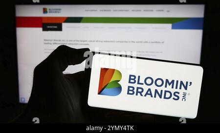 Stuttgart, Deutschland, 13.03.2024: Person mit Smartphone mit Logo der US-Restaurantholdinggesellschaft Bloomin' Brands Inc. Vor der Website. Fokus o Stockfoto