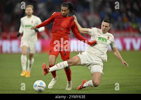 Tackle, Action Foul Michael Olise FC Bayern München FCB (17) gegen Keven Schlotterbeck FC Augsburg FCA (31) Allianz Arena, München, Bayern, Deutschland, Europa Stockfoto