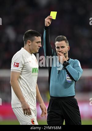 Schiedsrichter Daniel Schlager zeigt Keven Schlotterbeck FC Augsburg FCA (31) gelbe Karte gelbe Achtung Allianz Arena, München, Bayern, Deutschland, EUR Stockfoto