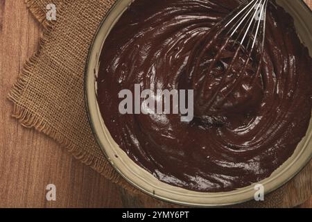 Eine Schüssel Schokoladenteig, ein Schneebesen zum Schlagen, Backen, Struktur und Konsistenz, hausgemacht, Draufsicht, keine Personen Stockfoto