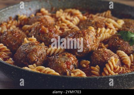 Hackfleischbällchen, in Tomatensauce, mit Fusilli-Nudeln, in einer gusseisernen Pfanne, selbstgemacht, keine Leute Stockfoto