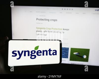 Stuttgart, 24.06.2024: Handybesitzer mit Logo der Schweizer agritech-Gesellschaft Syngenta Crop Protection AG vor Business Web p Stockfoto