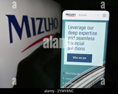 Stuttgart, Deutschland, 19.07.2024: Person, die ein Smartphone hält, mit der Webseite des japanischen Bankunternehmens Mizuho Financial Group Inc. Vor dem Logo. Fokus Stockfoto