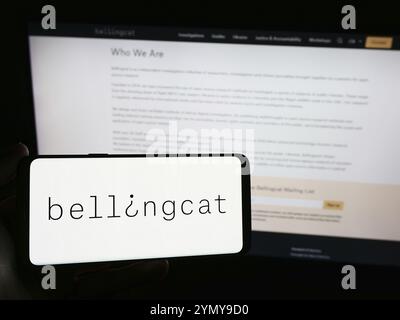 Stuttgart, Deutschland, 03.06.2024: Person mit Smartphone mit Logo der niederländischen Investigative Journalism Organisation Bellingcat vor der Website. Foc Stockfoto