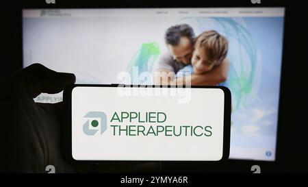 Stuttgart, Deutschland, 29.04.2024: Person, die ein Mobiltelefon mit dem Logo des amerikanischen biopharmazeutischen Unternehmens Applied Therapeutics Inc. Vor der Webseite hält Stockfoto