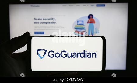 Stuttgart, Deutschland, 03.05.2024: Person, die ein Smartphone mit dem Logo des US-amerikanischen Bildungs-Software-Unternehmens Liminex Inc. (GoGuardian) vor der Website hält. Stockfoto