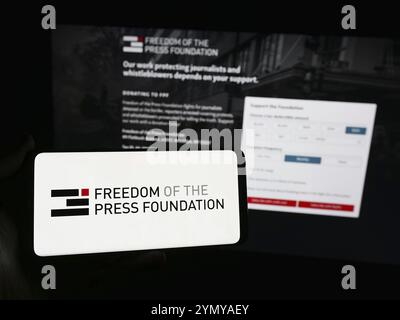 Stuttgart, Deutschland, 23.05.2024: Person mit Smartphone und Logo der Organisation „Freedom of the Press Foundation“ (FPF) vor der Website. Fokus o Stockfoto