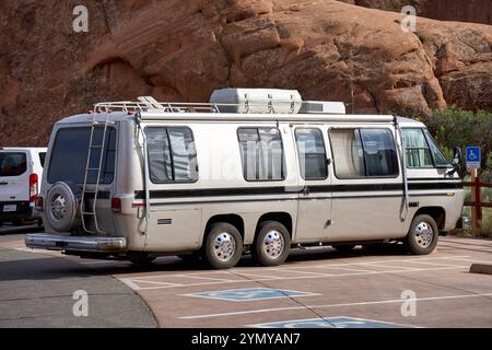 USA - 8. Juni 2024: Ein klassischer Wohnmobil-Bus parkt auf einem Behindertenparkplatz in einer Wüstenlandschaft der USA, umgeben von roten Felsformationen *** ein klassischer Wohnmobil-Bus parkt auf einem Behindertenparkplatz in einer Wüstenlandschaft der USA, umgeben von roten Felsformationen Stockfoto