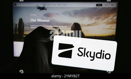 Stuttgart, Deutschland, 13.04.2024: Person, die ein Mobiltelefon mit dem Logo des amerikanischen Drohnenherstellers Skydio Inc. Vor der Business Web pag hält Stockfoto