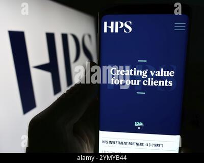 Stuttgart, Deutschland, 13.04.2024: Person, die ein Mobiltelefon hält, mit Website des US-amerikanischen Unternehmens HPS Investment Partners LLC vor dem Logo. Fokus auf Mitte o Stockfoto