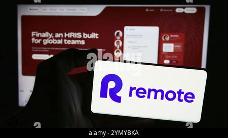 Stuttgart, Deutschland, 13.06.2024: Person, die ein Mobiltelefon mit dem Logo des amerikanischen HR-Softwareunternehmens Remote Technology Inc. Vor der Webseite hält. Foc Stockfoto