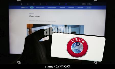 Stuttgart, Deutschland, 25.06.2024: Person, die ein Mobiltelefon mit dem Logo der Union Europäischer Fußballverbände (UEFA) vor der Webseite hält. Konzentrieren Sie sich auf Stockfoto