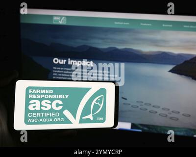 Stuttgart, Deutschland, 07.01.2024: Person mit Smartphone mit Logo der Organisation Aquaculture Stewardship Council (ASC) vor der Website. Fokus o Stockfoto