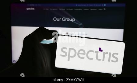 Stuttgart, Deutschland, 04-08-2024: Person, die ein Mobiltelefon mit dem Logo des britischen Präzisionsinstrumentationsunternehmens Spectris plc vor der Webseite hält. Fokussieren Stockfoto