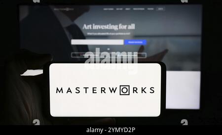 Stuttgart, Deutschland, 16.05.2024: Person, die ein Mobiltelefon mit Logo der US-amerikanischen Kunstinvestitionsgesellschaft Masterworks LLC vor der Webseite hält. Konzentrieren Sie sich auf Stockfoto
