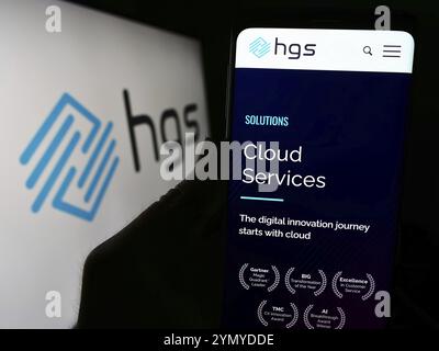 Stuttgart, Deutschland, 24.02.2024: Person mit Mobiltelefon mit Website des indischen Unternehmens Hinduja Global Solutions Limited (HGS) mit Logo. Konzentrieren Sie sich auf Stockfoto
