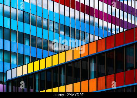 Farbenfrohe Fassade mit geometrischen Fenstermustern Stockfoto