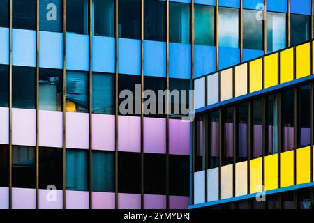 Farbenfrohe Fassade mit geometrischen Fenstermustern Stockfoto