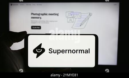 Stuttgart, Deutschland, 03-08-2024: Person, die ein Mobiltelefon mit dem Logo des US-amerikanischen KI-Unternehmens Supernormal Technologies Inc. Vor der Business-Webseite hält. Fokus Stockfoto