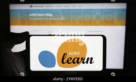 Stuttgart, Deutschland, 03-08-2024: Person, die ein Mobiltelefon mit Logo der Software Machine Learning-Bibliothek scikit-learn vor der Webseite hält. Konzentrieren Sie sich auf Stockfoto