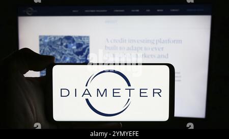 Stuttgart, Deutschland, 15.04.2024: Person, die ein Mobiltelefon mit dem Logo der US-amerikanischen Investmentgesellschaft Diameter Capital Partners LP vor der Business-Webseite hält. Stockfoto