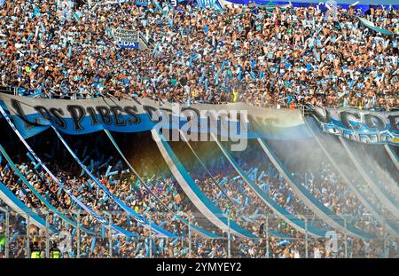 Die Fans des argentinischen Racing Clubs werden mit Wasser besprüht, während sie auf den Start des Finalspiels der CONMEBOL Copa Sudamericana gegen den brasilianischen Cruzeiro im La Nueva Olla Stadion in Asuncion, Paraguay, am 23. November 2024 warten. Stockfoto