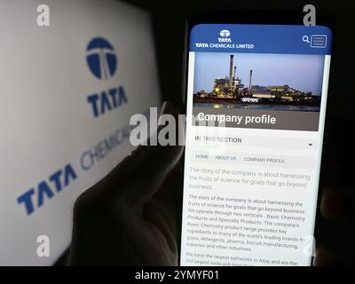 Stuttgart, Deutschland, 03.05.2024: Person mit Smartphone und Website des indischen Chemieunternehmens Tata Chemicals Limited vor dem Logo. Fokus auf ce Stockfoto