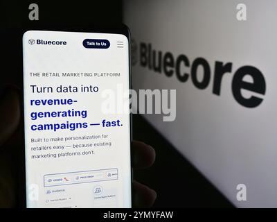 Stuttgart, Deutschland, 17.05.2024: Person, die ein Mobiltelefon hält, mit Webseite des US-amerikanischen Marketingtechnikunternehmens Bluecore Inc. Vor dem Logo. Konzentrieren Sie sich auf Cent Stockfoto