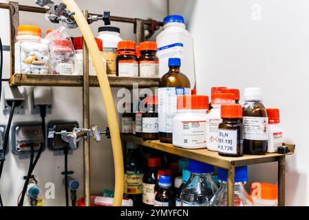 Organisierte chemische Reagenzien und Behälter auf Laborregalen, Hintergrund im Biochemie-Labor Stockfoto