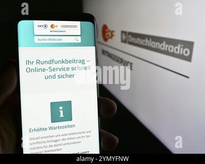 Stuttgart, Deutschland, 04.10.2024: Handybesitzer mit Internetseite des ARD ZDF Deutschlandradio Beitragsservice vor Logo. Konzentrieren Sie sich auf die Mitte Stockfoto