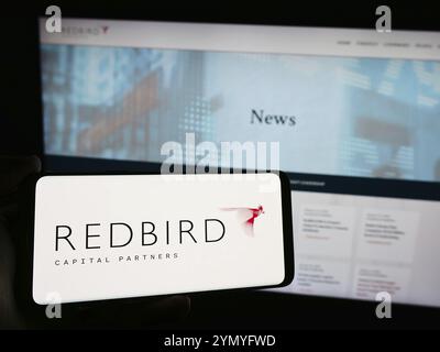 Stuttgart, Deutschland, 17.03.2024: Person, die ein Smartphone mit dem Logo der US-amerikanischen Investmentverwaltungsgesellschaft Redbird Capital Partners vor der Website hält. Stockfoto