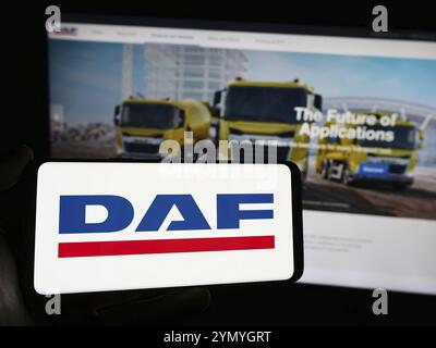 Stuttgart, Deutschland, 17.03.2024: Person, die ein Mobiltelefon mit dem Logo des niederländischen Lkw-Herstellers DAF Trucks NV vor der Business-Webseite hält Stockfoto