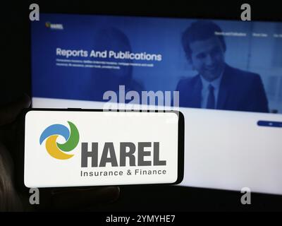 Stuttgart, Deutschland, 07-08-2024: Person mit Smartphone mit Logo von Harel Insurance Investments and Financial Services Ltd. Vor der Website. Fo Stockfoto