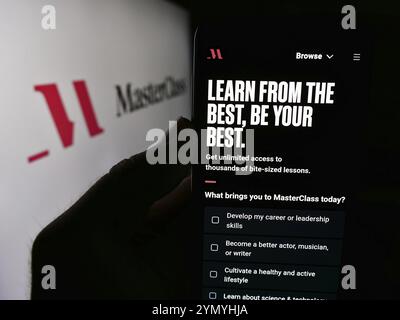 Stuttgart, Deutschland, 07.10.2024: Person, die ein Mobiltelefon mit Webseite des US-amerikanischen Bildungsunternehmens Yanka Industries Inc. (Masterclass) mit Logo hält. Konzentrieren Sie sich auf Stockfoto